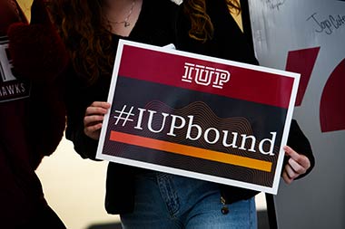 a student holding a #IUPbound poster