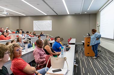parents and students sitting in a room for a presentation
