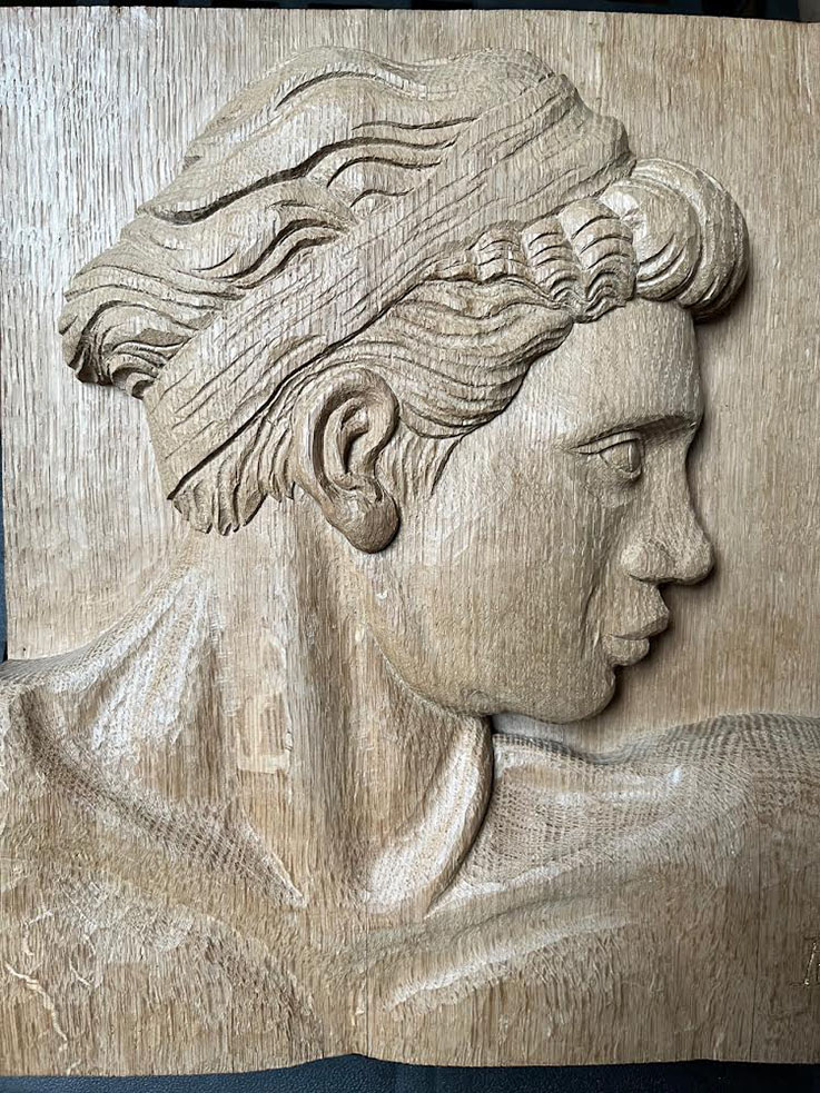 wooden carved relief of a human face