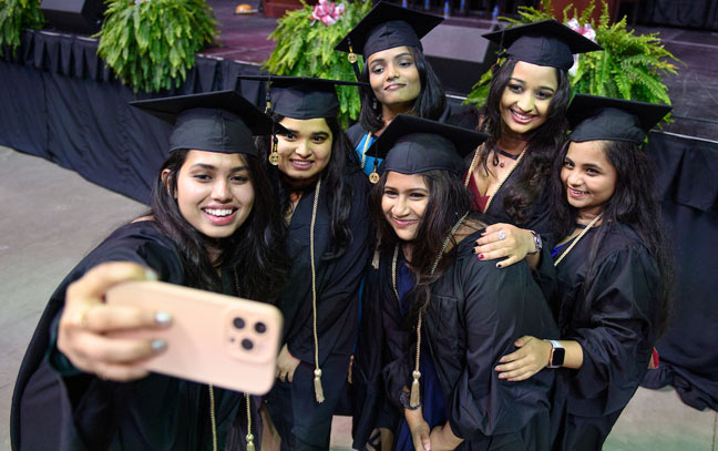 group of graduates at commencement taking a selfie