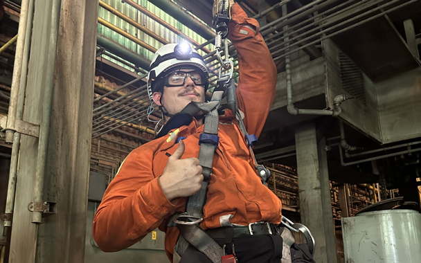 a student in a safety harness hangs in a construction building