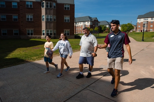 a family walking through campus with a tour guide