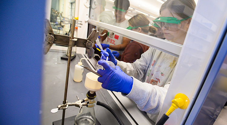 a student in a lab working with chemicals