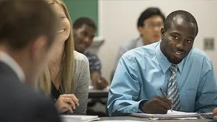 people sitting at a table in a classroom