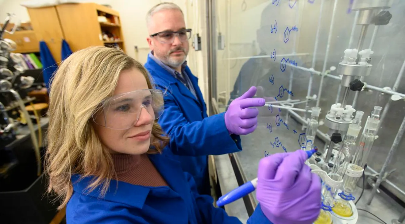 a student working in a science lab with her professor