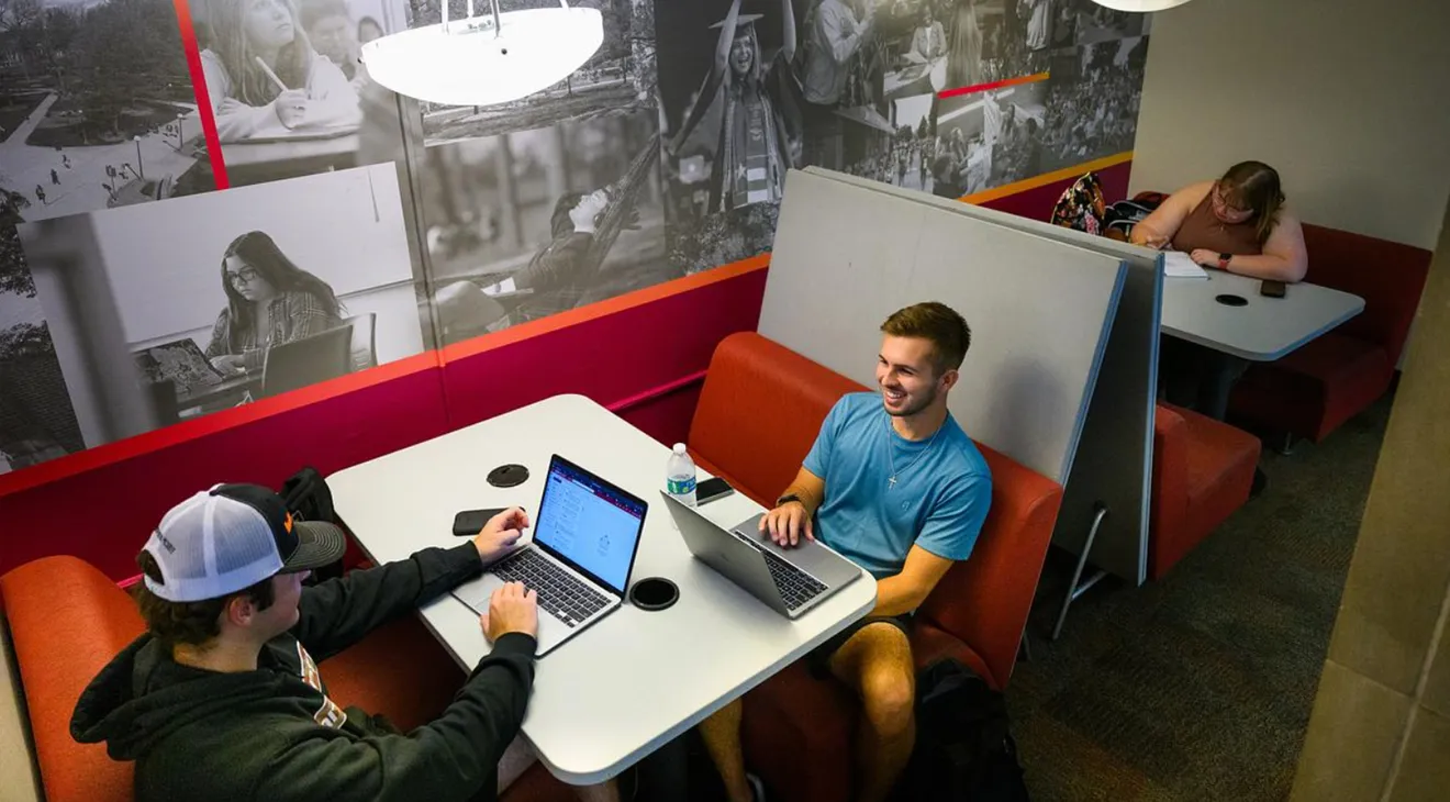 students sitting at a booth in the library