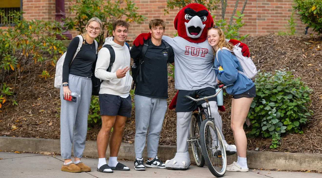 students taking a photo with Norm in the oak grove