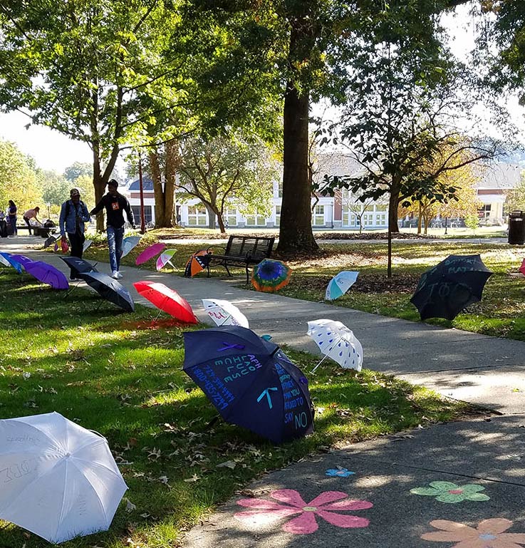 RAINN Day, umbrellas lining sidewalks in the Oak Grove with chalk designs on the walks