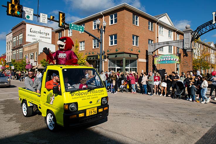 norm and others waving from a truck during the homecoming parade