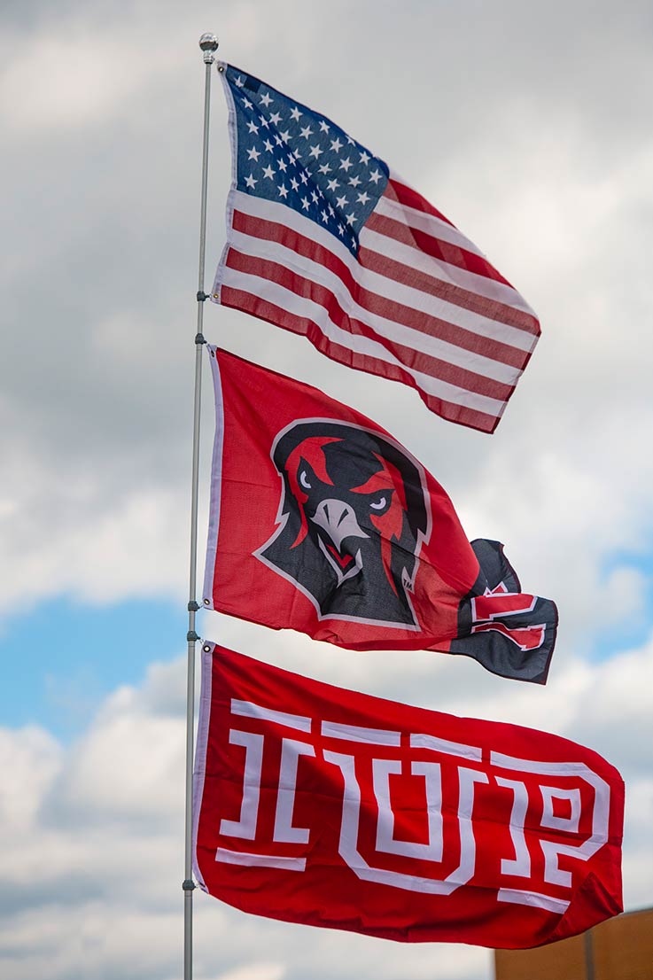 IUP flags and the American flag fly during 2023 tailgating