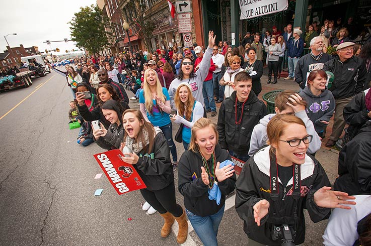 group of people gathered on the street during homecoming