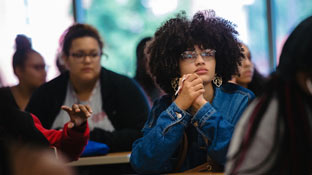 photo of a female student listening to a lecture in class