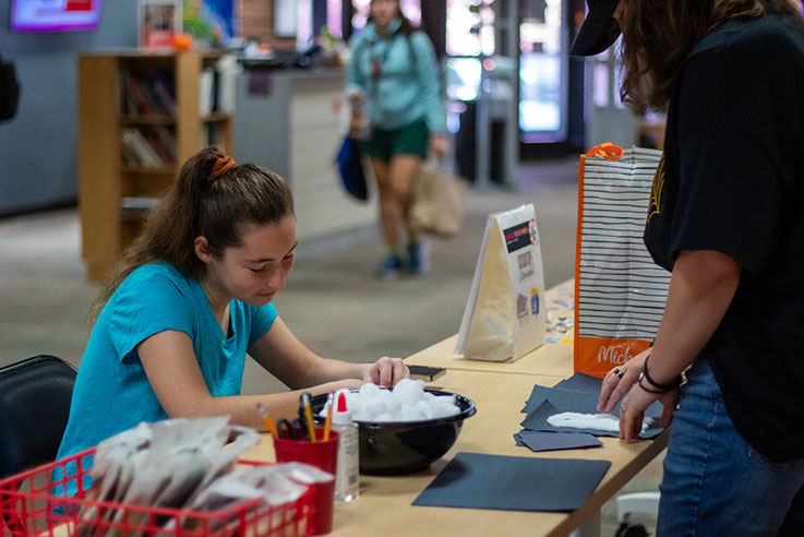 A student participates in crafting activities during Halloween at the IUP Libraries.