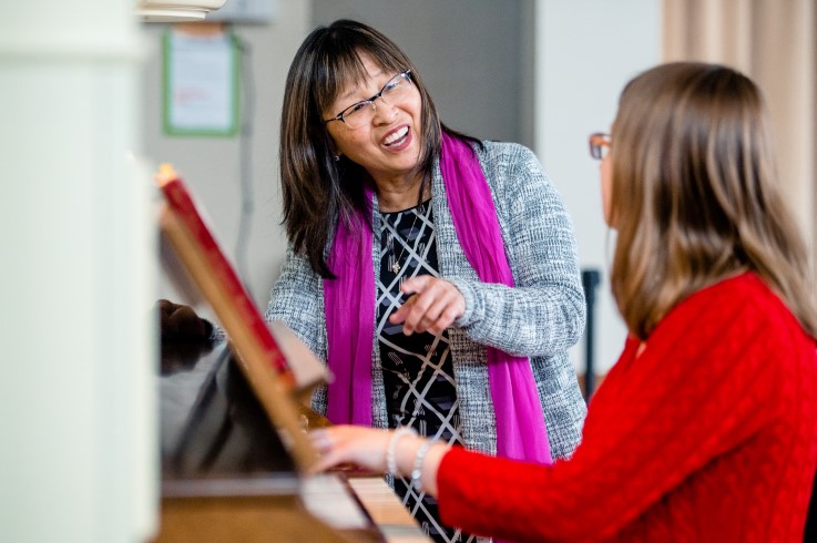 Professor Christine Clewell teaching a student at a piano