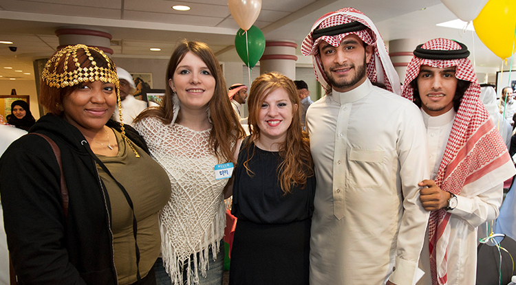 Students dressed in international garb and smiling