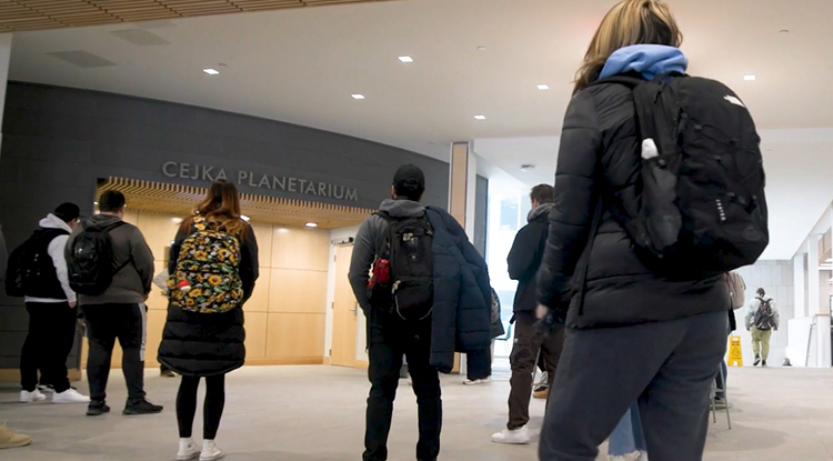 students walking in front of the planetarium