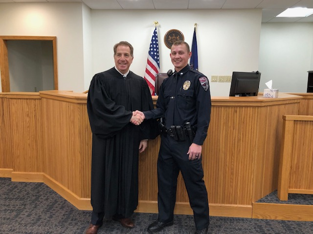 Officer Brayden Bumgardner shaking hands with Indiana County Magisterial District Judge Anthony Sottile III