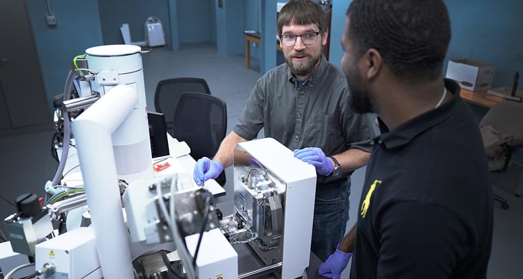 Two students working with the scanning electron microscope