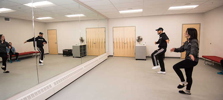 Students practicing before mirrors in the Dance Studio 